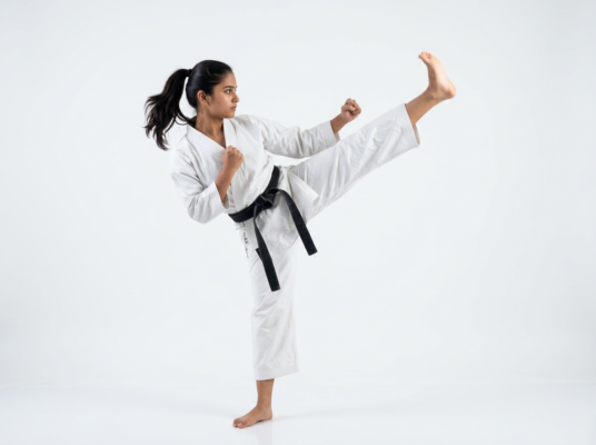 Firefly_Gemini Flash_Young indian student isolated doing karate kick, in karate attire, side camera shot, 699780