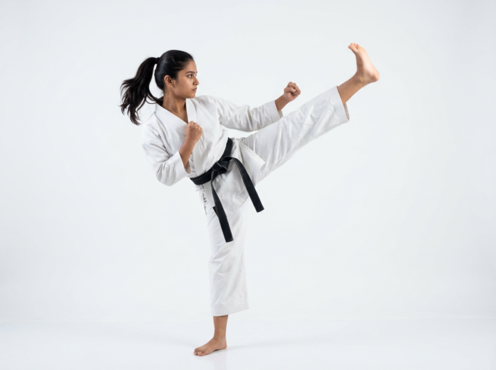 Firefly_Gemini Flash_Young indian student isolated doing karate kick, in karate attire, side camera shot, 699780